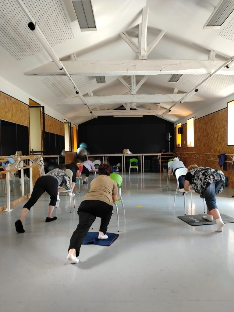 Pratique de yoga au sol dans une grande salle lumineuse