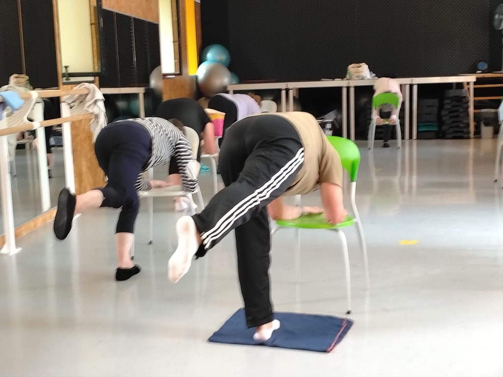 Pratiquantes en posture de flexion avant pendant un cours de yoga