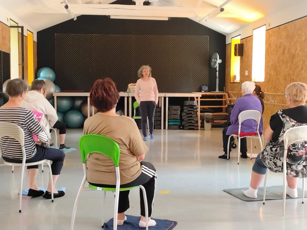 Participantes assises sur des chaises pendant une séance de yoga adapté