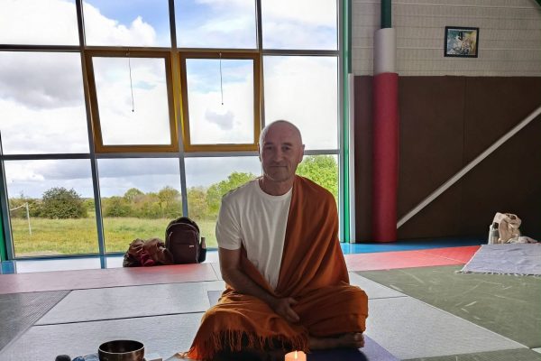Dom Ananda assis en méditation dans la salle des Arts Martiaux de La Verrie